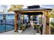 Backyard poolside patio area featuring an outdoor pavilion with draped curtains and stylish furniture at 1720 Hope Dr, Ormond Beach, FL 32174
