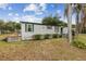 Charming single-story home with green trim, a wood deck, and mature landscaping at 18600 Old Cheney Hwy, Orlando, FL 32820