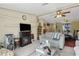 Cozy living room with a fireplace, ceiling fan and view into dining area at 18600 Old Cheney Hwy, Orlando, FL 32820
