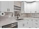Close-up of a kitchen featuring bright white cabinetry, a stainless steel sink, and elegant countertops at 197 Flame Ave, Maitland, FL 32751
