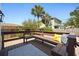 Cozy wooden deck with bench seating, patterned rug, and a view of lush landscaping at 2107 Delaney Ave, Orlando, FL 32806