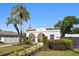 Beautiful home showcasing manicured landscaping, mature palm trees and a delightful arched entryway at 2107 Delaney Ave, Orlando, FL 32806