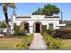 Inviting home displaying tidy landscaping, a brick pathway, and an attractive arched entryway at 2107 Delaney Ave, Orlando, FL 32806