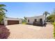 Home exterior featuring an oversized driveway, detached garage, and lovely landscaping at 2107 Delaney Ave, Orlando, FL 32806