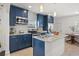 Well-equipped kitchen with stainless steel appliances, granite counters, and blue cabinetry at 2107 Delaney Ave, Orlando, FL 32806