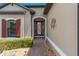 Inviting front entry with a brick walkway, decorative wall art, and meticulously maintained landscaping at 2530 Stargrass Cir, Clermont, FL 34715