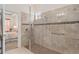 Tiled walk-in shower with a glass door, handheld sprayer, and built-in bench seat at 2530 Stargrass Cir, Clermont, FL 34715