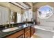 Bathroom with double sink vanity, bathtub, and window at 2626 Clarinet Dr, Orlando, FL 32837