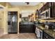 Stainless steel refrigerator, oven, and microwave complement the dark cabinets and granite countertops at 2626 Clarinet Dr, Orlando, FL 32837