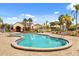A resort style community pool with palm trees, lounge chairs, and nearby clubhouse on a sunny day at 2626 Clarinet Dr, Orlando, FL 32837