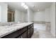 Spacious bathroom with double sink vanity, tub, and dark wood cabinets at 2638 Giardino Loop, Kissimmee, FL 34741