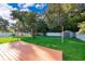 Spacious backyard with lush green grass, mature trees, wooden deck and a storage shed at 3024 Sutton Dr, Orlando, FL 32810
