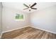 Bright bedroom featuring wood-look floors, a ceiling fan, and a window providing natural light at 3024 Sutton Dr, Orlando, FL 32810