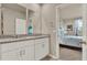 Bathroom with double vanity, granite countertop, white cabinets, and view to the bedroom at 30276 Armenia Rd, Leesburg, FL 34748