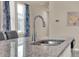 Kitchen island features granite countertop, stainless steel sink and modern faucet at 30276 Armenia Rd, Leesburg, FL 34748