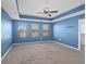 Light-filled bedroom with tray ceiling, plush carpeting, and large windows showcasing neighborhood views at 335 Merry Brook Cir, Sanford, FL 32771