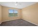 Bedroom showcasing large window views, neutral walls, carpeted floors, and a ceiling fan, offering a tranquil retreat at 335 Merry Brook Cir, Sanford, FL 32771