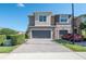 Charming townhome with a two-car garage and brick-paved driveway, complemented by lush greenery at 335 Merry Brook Cir, Sanford, FL 32771