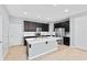 Modern kitchen with stainless steel appliances, white quartz countertop island, and dark cabinets at 335 Merry Brook Cir, Sanford, FL 32771