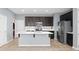 Modern kitchen featuring a center island, stainless steel appliances, and dark cabinetry at 335 Merry Brook Cir, Sanford, FL 32771