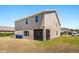 Backyard view with a house, grass and waste bins at 340 Irving Bend Dr, Groveland, FL 34736