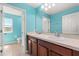 Bright bathroom featuring dual sinks with a large mirror and blue walls at 340 Irving Bend Dr, Groveland, FL 34736