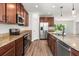 Kitchen featuring stainless steel appliances, wood cabinets, and stone countertops at 340 Irving Bend Dr, Groveland, FL 34736