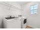 Well-lit laundry room featuring a washer, dryer, and wire shelving at 340 Irving Bend Dr, Groveland, FL 34736