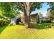 Beautiful backyard with lawn, mature tree, and home exterior at 3509 Battersea Ct, Belle Isle, FL 32812