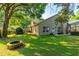 Lush backyard with green grass, mature trees, a firepit and covered storage at 3509 Battersea Ct, Belle Isle, FL 32812
