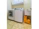 Convenient laundry room with tiled floor, white washer and dryer, utility sink, and storage at 3509 Battersea Ct, Belle Isle, FL 32812