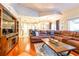 Spacious living room featuring a leather sectional sofa, hardwood floors and an open floor plan into the kitchen at 3509 Battersea Ct, Belle Isle, FL 32812