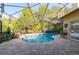 Beautiful screened pool area with a paved patio, outdoor dining, and lush landscaping at 3509 Battersea Ct, Belle Isle, FL 32812