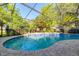 Well maintained screened pool area, patio, dining table, and mature landscaping at 3509 Battersea Ct, Belle Isle, FL 32812
