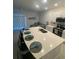 Bright kitchen featuring an island with bar seating, white cabinetry, and stainless steel appliances at 3623 Main Harbor Dr, Kissimmee, FL 34746