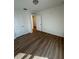 A bright bedroom features neutral walls and attractive wood-look flooring with a view into the hallway at 366 Madison Dr, Davenport, FL 33837