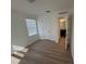A comfortable bedroom has wood-look flooring, large window, and view into the bathroom at 366 Madison Dr, Davenport, FL 33837
