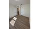 A bright bedroom features neutral walls and attractive wood-look flooring and an open doorway at 366 Madison Dr, Davenport, FL 33837