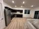 A kitchen featuring stainless steel appliances, dark cabinetry, granite countertops, and wood-look flooring at 366 Madison Dr, Davenport, FL 33837