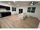 A living room featuring wood-look flooring, natural light, and a ceiling fan, with covered furniture at 366 Madison Dr, Davenport, FL 33837