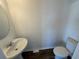 A powder room featuring a pedestal sink, toilet, and dark wood-look flooring at 366 Madison Dr, Davenport, FL 33837