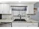 Kitchen area featuring granite countertops, white cabinets, and modern faucet at 387 Kantor Blvd, Casselberry, FL 32707
