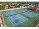 Aerial view of community tennis courts, featuring well-maintained blue courts, green perimeter, and surrounding neighborhood homes at 387 Kantor Blvd, Casselberry, FL 32707