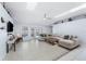 Expansive living room with a large sofa, skylights, and access to outdoor pool area at 4008 Lakeside Reserve Ct, Orlando, FL 32810