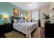 Cozy bedroom featuring a queen-size bed with floral bedding, side tables and a bright window at 4126 Breakview Dr # 40901, Orlando, FL 32819