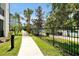 Scenic paved walkway lined with lush landscaping, palm trees, and a lake view at 4126 Breakview Dr # 40901, Orlando, FL 32819