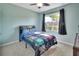 Comfortable bedroom with a vibrant comforter, plush carpeting, and natural light from the window at 424 Lazio Cir, Debary, FL 32713