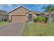 Charming single-story home with brick driveway, well-maintained lawn, and mature palm tree at 424 Lazio Cir, Debary, FL 32713