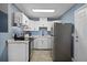 Efficient kitchen with white cabinets, stainless steel refrigerator, and wood-look flooring at 4274 Tatum St, Orlando, FL 32811