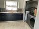 Functional kitchen with dark cabinets, grey subway tile backsplash, and a window over the sink at 434 Diamond Acres Rd, Davenport, FL 33837